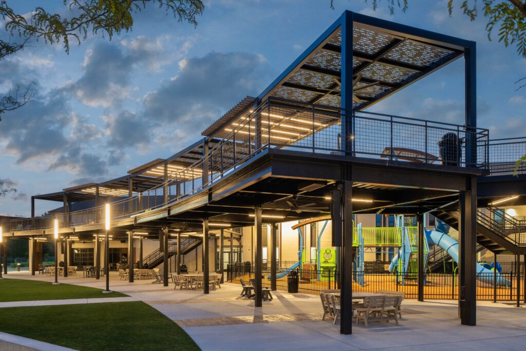 Church construction company Visioneering Studios designed Long Hollow Baptist Church's Legacy Park with a community-centric outdoor hub that includes a metal structure for with seating areas that provide shade for the community